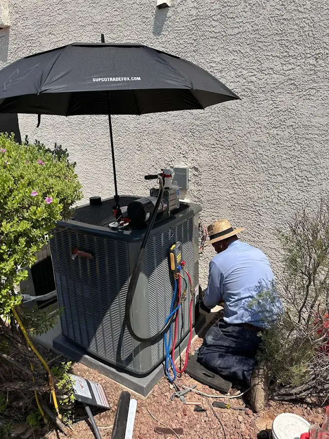 HVAC technician performing outdoor AC maintenance in Hood River