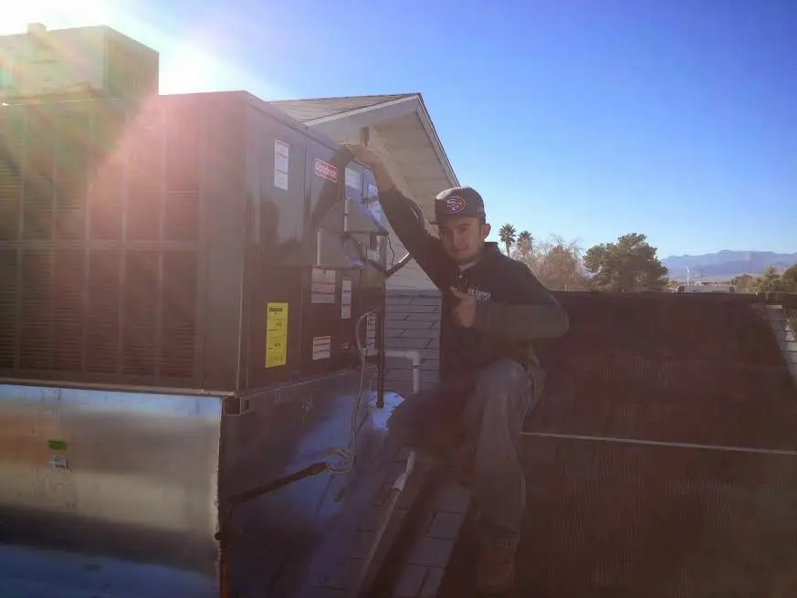 HVAC technician performing HVAC Inspection on a rooftop unit in Hood River